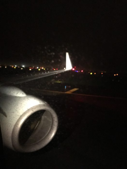 飛機降落在紐約肯尼迪國際機場，窗外落着雨